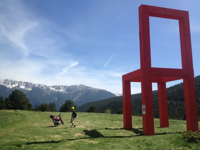 Manuel junto a la silla roja gigante al lado de el Mirador Roc del Quer
