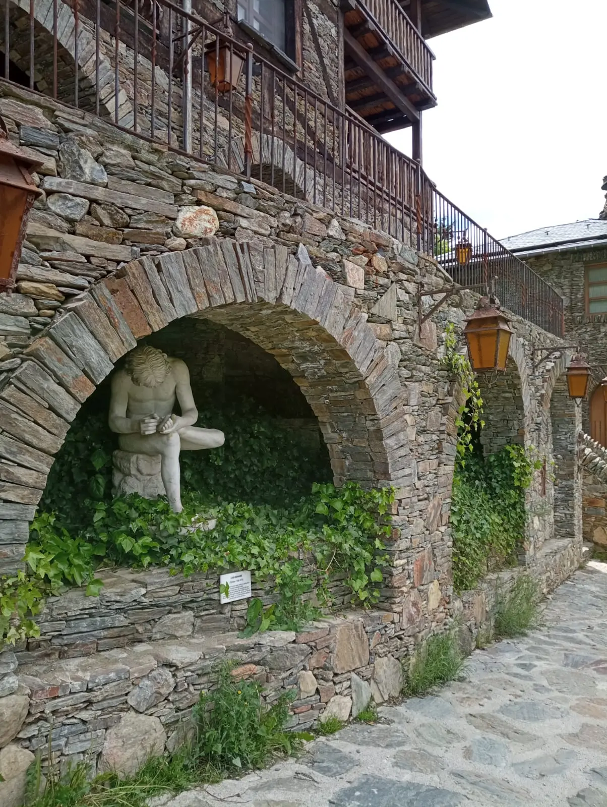 Sculpture sous une arche en pierre à Auvinyà