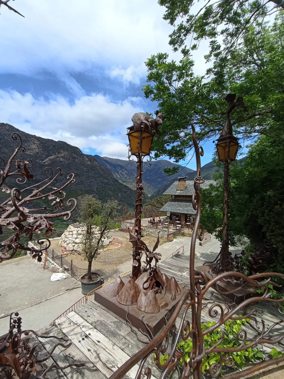 Sculptures en fer et restaurant au fond à Auvinyà