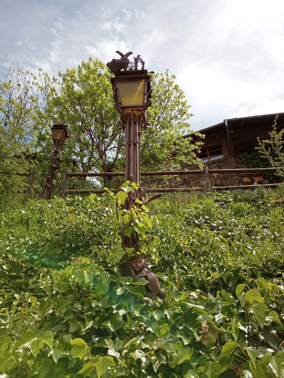 Sculpture de lapin sur lampadaire et chat à Auvinyà