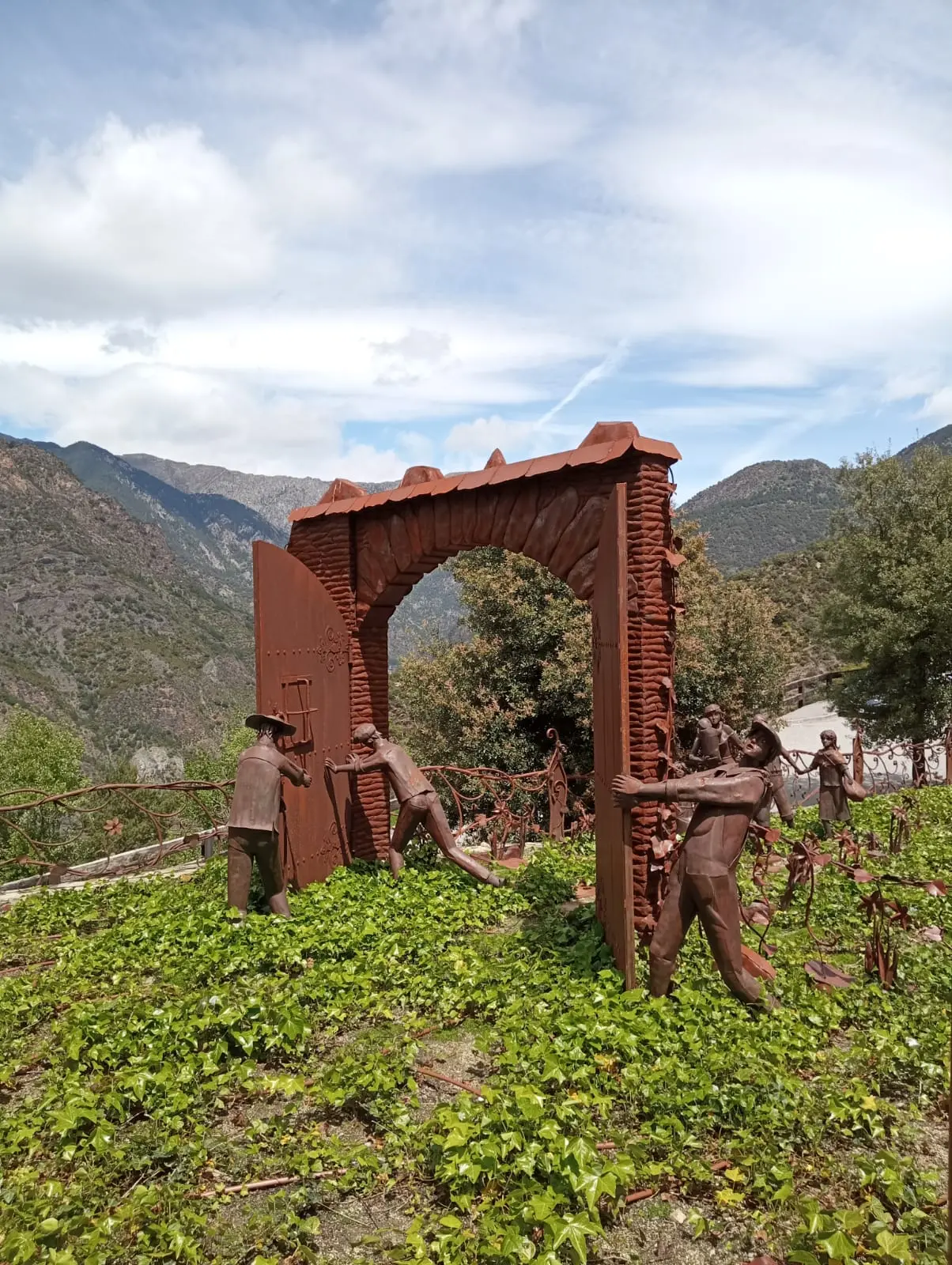 Portail de sortie avec sculptures de réfugiés à Auvinyà